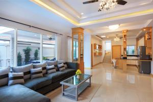 sala de estar con sofá y mesa en Pattaya Private Villa - Pool,Sauna,Snooker,BBQ en Pattaya South