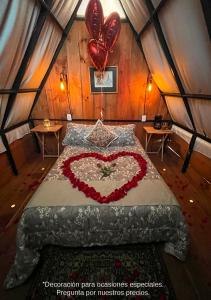 - une chambre avec un lit en forme de cœur et 2 ballons dans l'établissement Cabañas Yei Calli, à Ciudad Mendoza