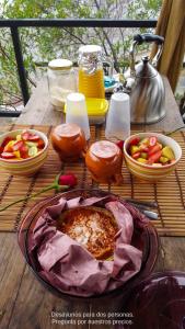 una mesa con un plato de comida y tazones de fruta en Cabañas Yei Calli, en Ciudad Mendoza
