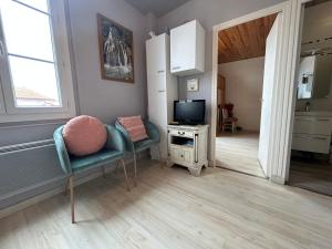 ein Wohnzimmer mit einem Stuhl und einem TV in der Unterkunft Appartement Urrugne, 2 pièces, 2 personnes - FR-1-239-508 in Urrugne