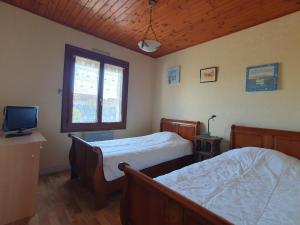 1 dormitorio con 2 camas y TV. en Maison L'Aiguillon-sur-Mer, 5 pièces, 6 personnes - FR-1-476-135, en LʼAiguillon-sur-Mer