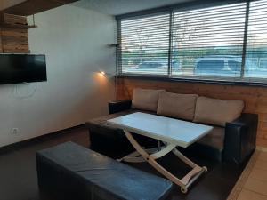 a living room with a table and a couch at Charmant T2 rénové à Capbreton à 2 min de la plage avec parking privé - FR-1-239-901 in Capbreton