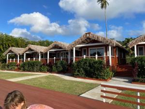 Una donna seduta di fronte a un resort di Red Hibiscus Villas a Rarotonga