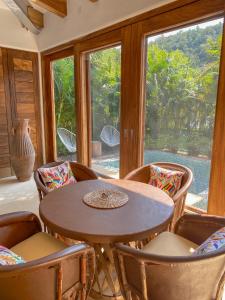 Habitación con mesa, sillas y ventana en Casa Mon Repos en Careyes, en Careyes