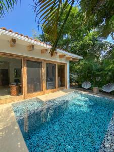 a swimming pool in front of a house at Casa Mon Repos en Careyes in Careyes
