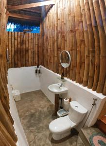 a bathroom with a toilet and a sink and a tub at Kahoy Cottages in Siquijor