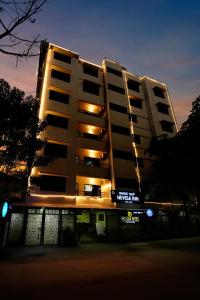 ein großes Apartmenthaus mit einem Schild davor in der Unterkunft Nevesa Inn in Bangalore