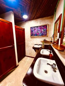 uma casa de banho com lavatório e duas portas vermelhas em HOLBOX HOSTAL em Holbox