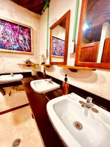 a bathroom with two sinks and two mirrors at HOLBOX HOSTAL in Holbox Island