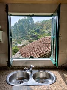 lavabo frente a una ventana con vistas en Canastro Nature Spot, en Viseu
