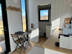 a kitchen with a table and a counter with a window at Willow Three Tiny House in Willow Tree