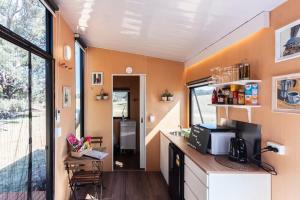 an interior view of a tiny house with a counter and a kitchen at Hermano Farm Stay 