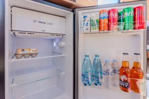 un frigorifero aperto con bevande e bibite gassate di Hermano Farm Stay 