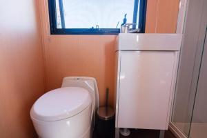 La petite salle de bains est pourvue de toilettes et d'un lavabo. dans l'établissement Hermano Farm Stay, 