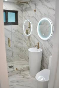 a bathroom with a sink and a toilet and mirrors at Stylish home in Dania Beach