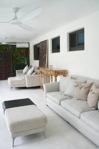 una sala de estar con sofás blancos y una mesa. en Stylish home, en Dania Beach