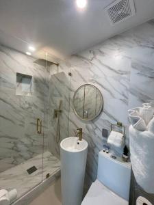 a bathroom with a toilet and a sink and a shower at Stylish home in Dania Beach