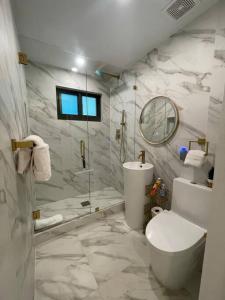 a bathroom with a shower and a toilet and a sink at Stylish home in Dania Beach