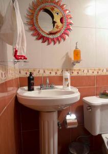 a bathroom with a sink and a mirror and a toilet at Xochi Calli in Nogales