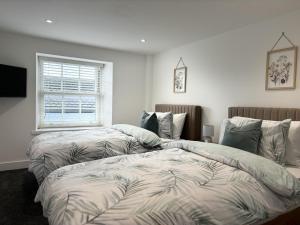 1 dormitorio con 2 camas y ventana en Hardy Hideaway, en Ulverston