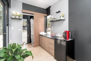 a kitchen with a black refrigerator and some plants at Tiny House 888 in Pokolbin