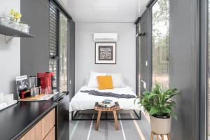 a small bedroom with a bed and a desk at Tiny House 888 in Pokolbin