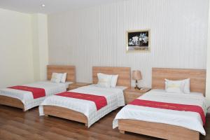 a room with two beds with white and red sheets at Nhà Khách Hương Sen in Hai Phong