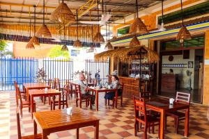 a restaurant with tables and chairs and people sitting at them at Le Tonle in Kratie