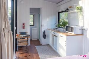 a kitchen with a sink and a microwave at Kawal Tiny House in Wollombi