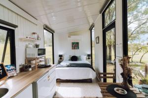 a bedroom in a tiny house with a bed and a sink at Willow Dale Farm in Paterson