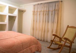 Xochi Calli في Nogales: غرفة نوم بسرير وكرسي ونافذة