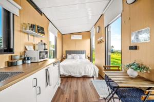 eine Küche und ein Wohnzimmer mit einem Bett in einem winzigen Haus in der Unterkunft Vine View Escape in Rothbury
