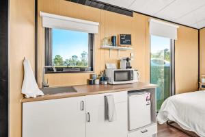 eine Küche mit einer Mikrowelle und ein Bett in einem Zimmer in der Unterkunft Vine View Escape in Rothbury