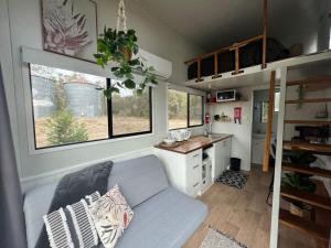 a living room with a couch in a tiny house at Yellow Rock Views in Broke