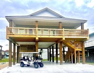 Bolivar PeninsulaCalypso Cove-3bd 2b-Sleeps up to 12的停放在大房子前面的高尔夫球车