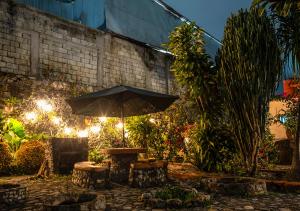 a table with an umbrella in a garden at night at Xochi Calli in Nogales