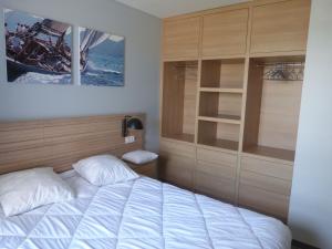 a bedroom with a bed and a large cabinet at Appartement luxe avec piscine, animaux admis, climatisation et parking à La Tranche-sur-Mer - FR-1-194-227 in La Tranche-sur-Mer