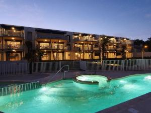 a swimming pool in front of a building at night at Appartement luxe avec piscine, animaux admis, climatisation et parking à La Tranche-sur-Mer - FR-1-194-227 in La Tranche-sur-Mer
