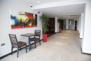 a room with a table, chairs, and tables at Ramada Milton Keynes in Milton Keynes