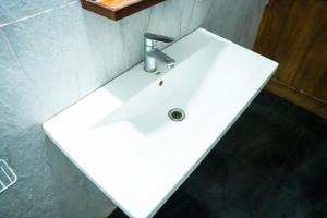 a white bathroom sink with a chrome faucet at Elegant Riverside Resort in Dematapelessa