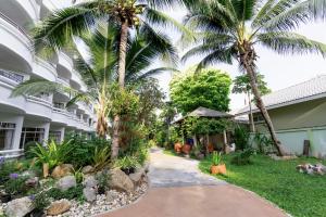 MATCHA SAMUI RESORT formerly Chaba Samui Resort في شاطئ تشاوينغ: ممشى امام مبنى فيه نخيل