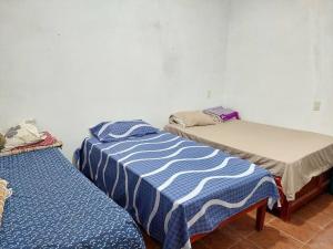 dwa łóżka siedzące obok siebie w pokoju w obiekcie La casa del descanso w mieście Catemaco