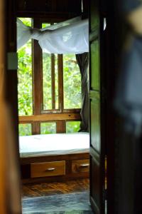 a view of a window with a bed in a room at Tini Wood House in Hue