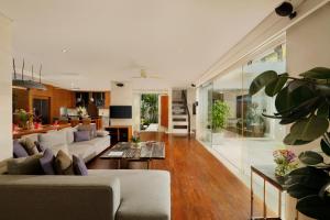ein Wohnzimmer mit einer Couch und einem Tisch in der Unterkunft Villa Camellia by Nakula in Jimbaran