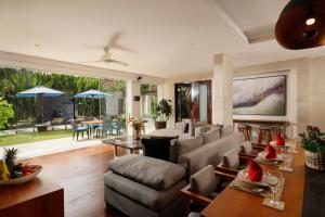 ein Wohnzimmer mit einer Couch und einem Tisch in der Unterkunft Villa Camellia by Nakula in Jimbaran