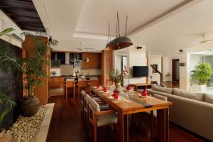 ein Wohnzimmer mit Tisch und Couch in der Unterkunft Villa Camellia by Nakula in Jimbaran