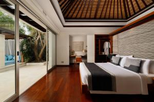 ein Schlafzimmer mit großem Bett und Balkon in der Unterkunft Villa Camellia by Nakula in Jimbaran