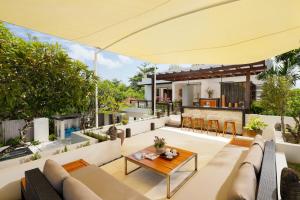eine Außenterrasse mit einem Sofa und einem Tisch in der Unterkunft Villa Camellia by Nakula in Jimbaran