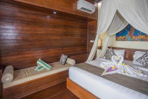 two beds in a room with wooden walls and wooden floors at D'Muncuk Huts Lembongan in Nusa Lembongan