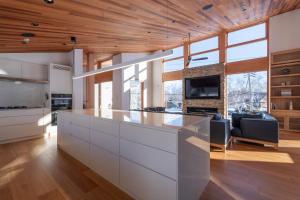 a kitchen with white cabinets and a large window at Ro-An in Kutchan